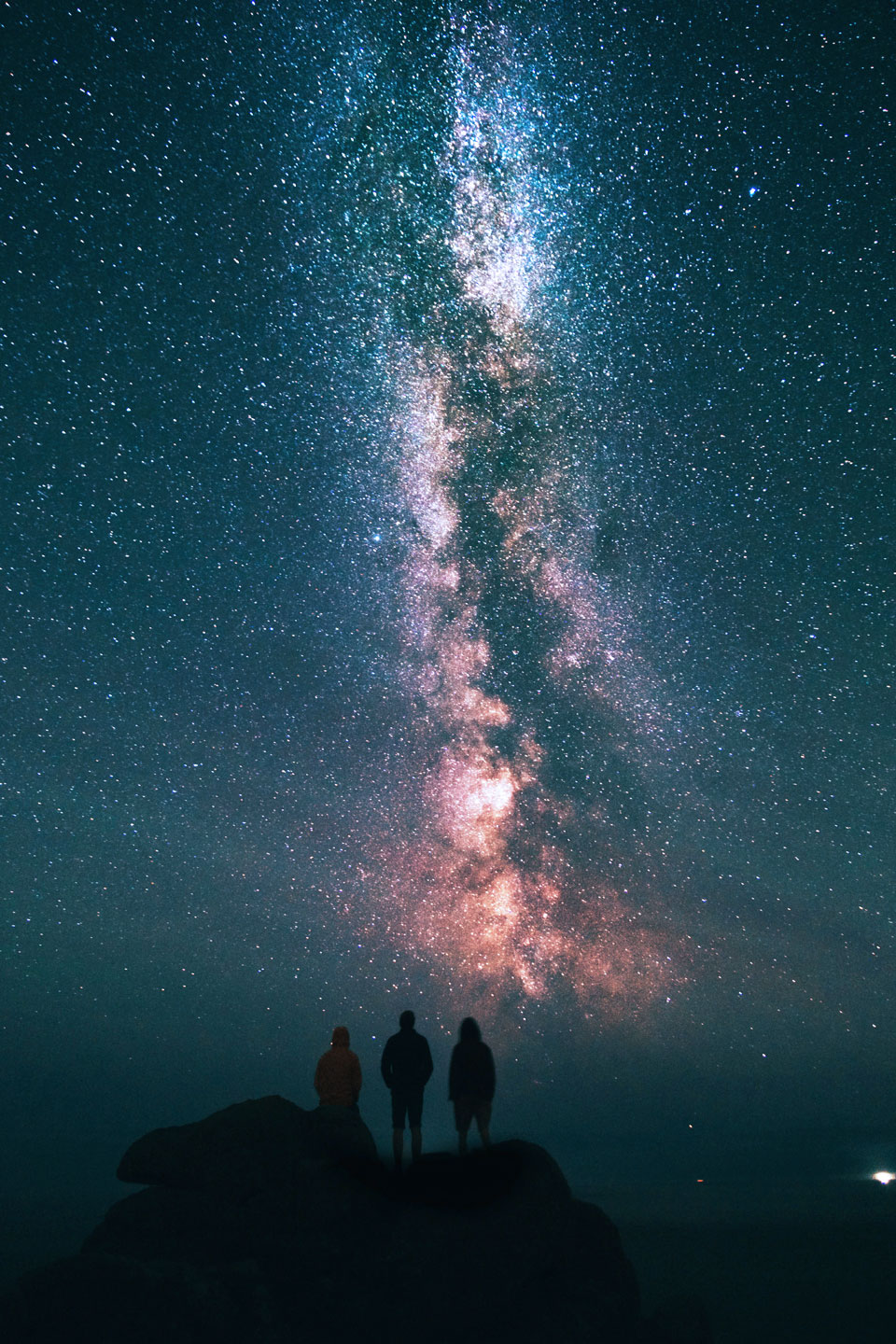 Three people's silhouettes watching the night sky